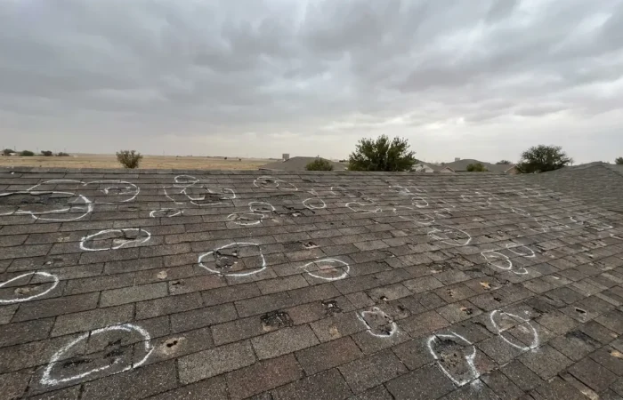Hail-damaged asphalt shingle roof chalk-marked during a hail damage roof repair inspection in Lubbock, TX