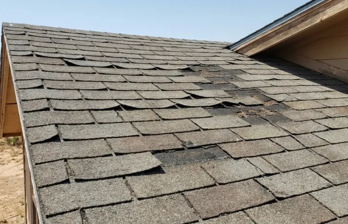 Curling shingles and granule loss on an aging Lubbock roof — classic signs you need a new roof