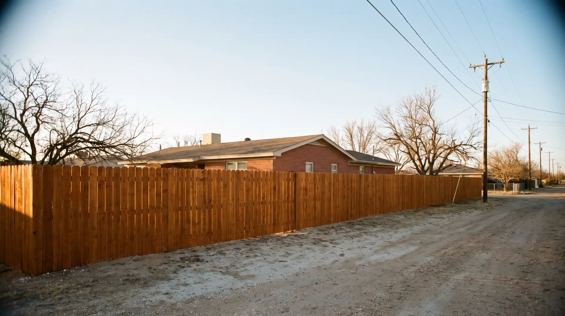 Weathered gray driftwood stain on a backyard fence with dark trim and modern siding