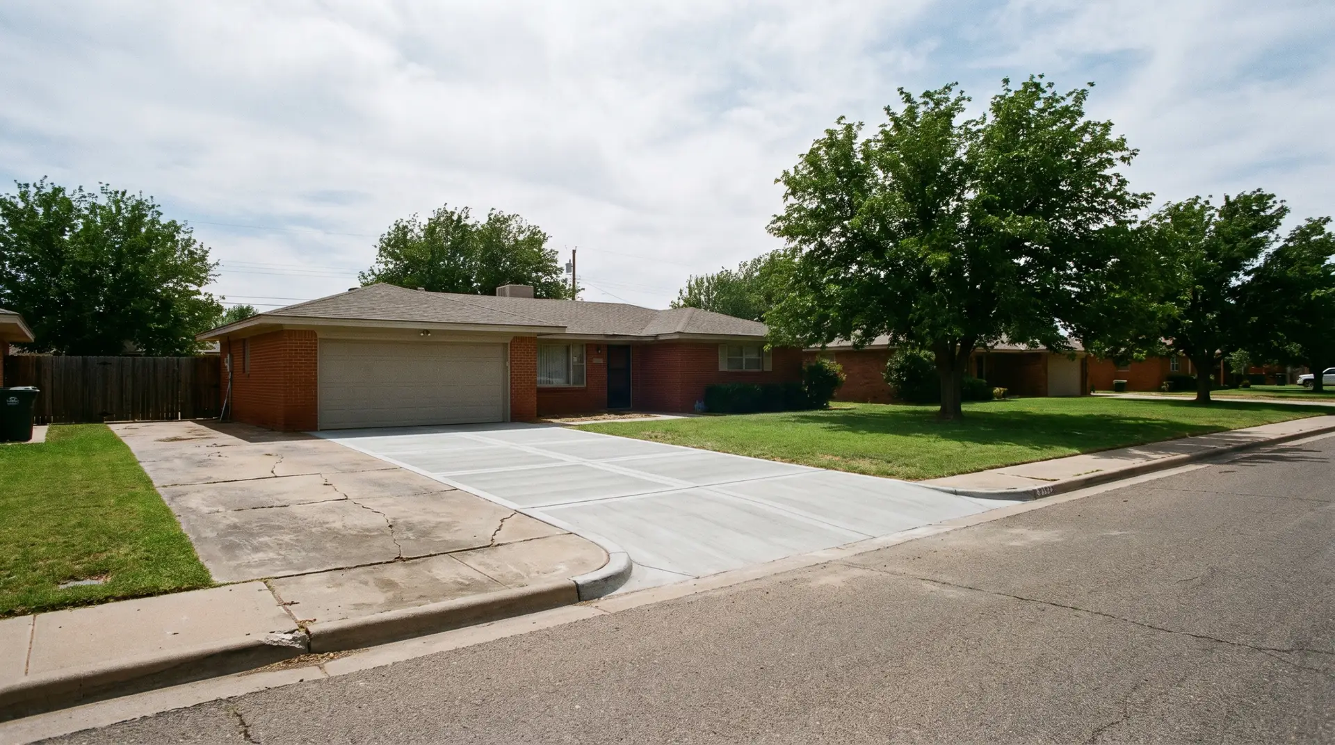 Freshly poured and finished concrete driveway with clean control joints at a Lubbock house