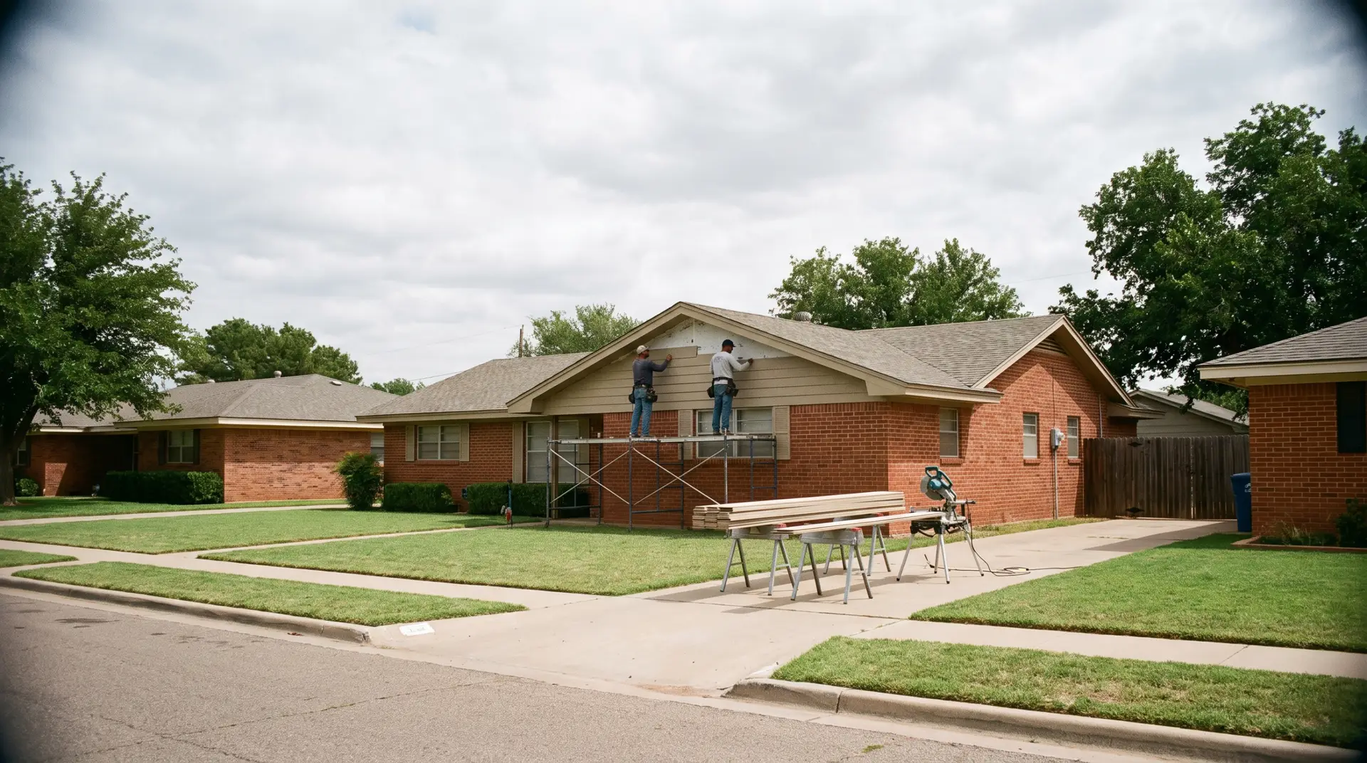 Crew installing fiber cement siding options on a Lubbock brick ranch home wall